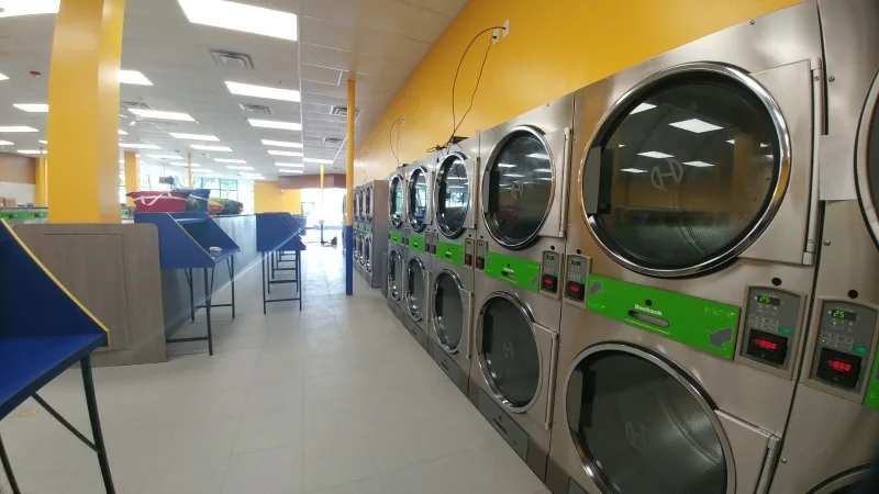 Completed laundromat interior with rows of washers and folding tables